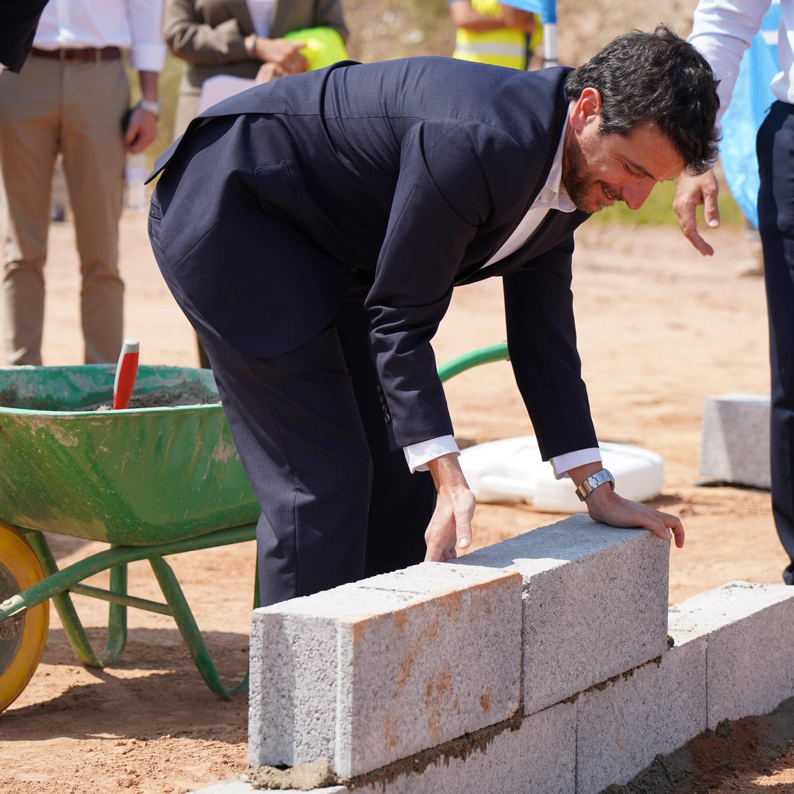 Der Körber-Vertreter legt symbolisch einen Ziegelstein zur Einweihung der neuen Produktionsstätte in Portugal.